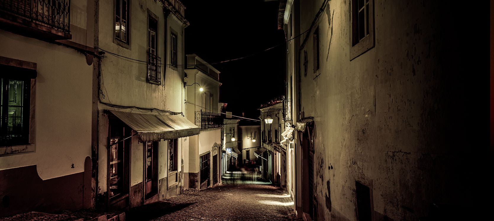 Photo of Evora, Portugal at Night. Sloped alleyways.