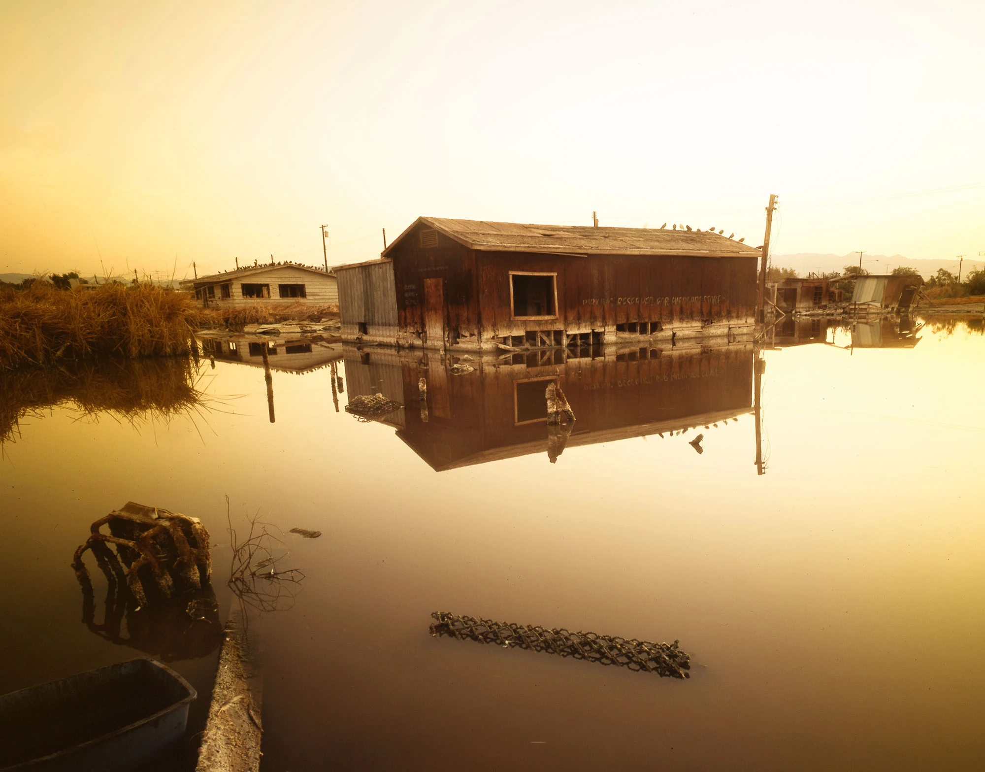Derelict buildings at Bombay Beach on California's Salton Sea, their weathered walls and peeling paint standing as relics of a once-thriving resort town now succumbing to abandonment and environmental decline.