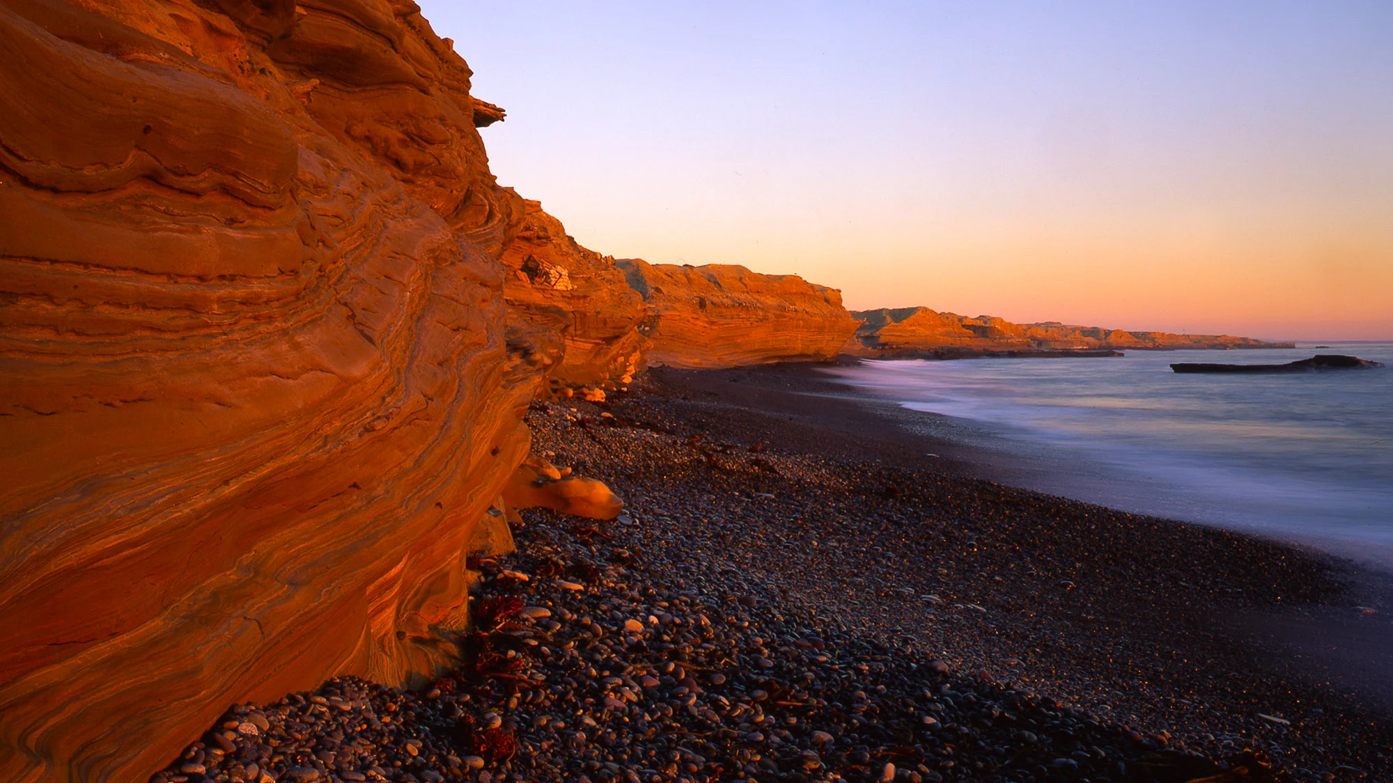 Narrow dusk alley in Rovinj, Croatia—warm stone walls, glowing windows and lantern light, polished cobbles tapering toward the sea—an invitation to wander and discover Europe.