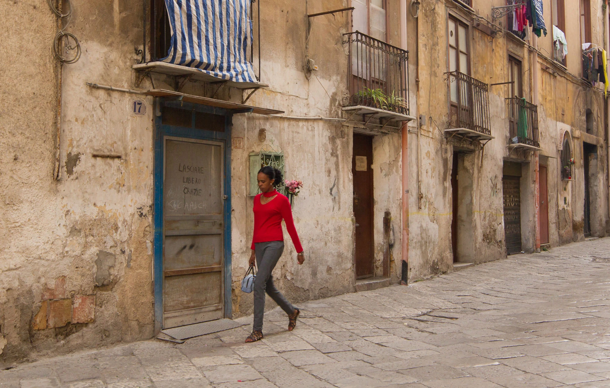 A woman walks in the Kalsa District of Palermo, Sicily.