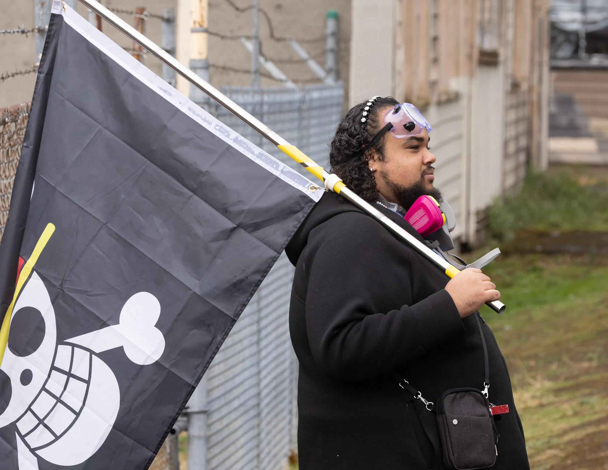A Portland protester waves a pirate flag in front of the ICE building, symbolizing defiance and humor in the city's resistance to federal overreach.