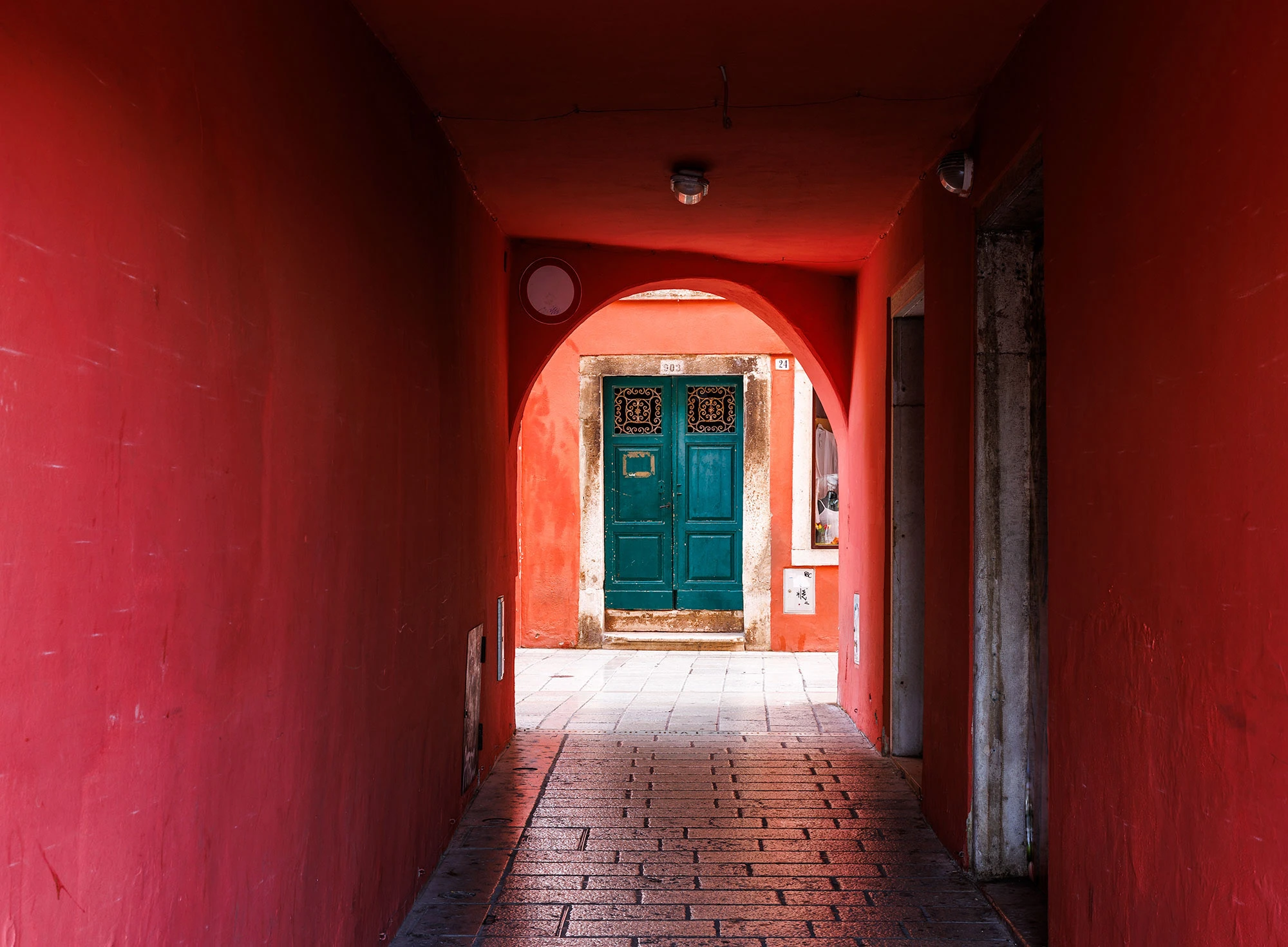 A green door is visible beyond a fiery red archway in Istria.