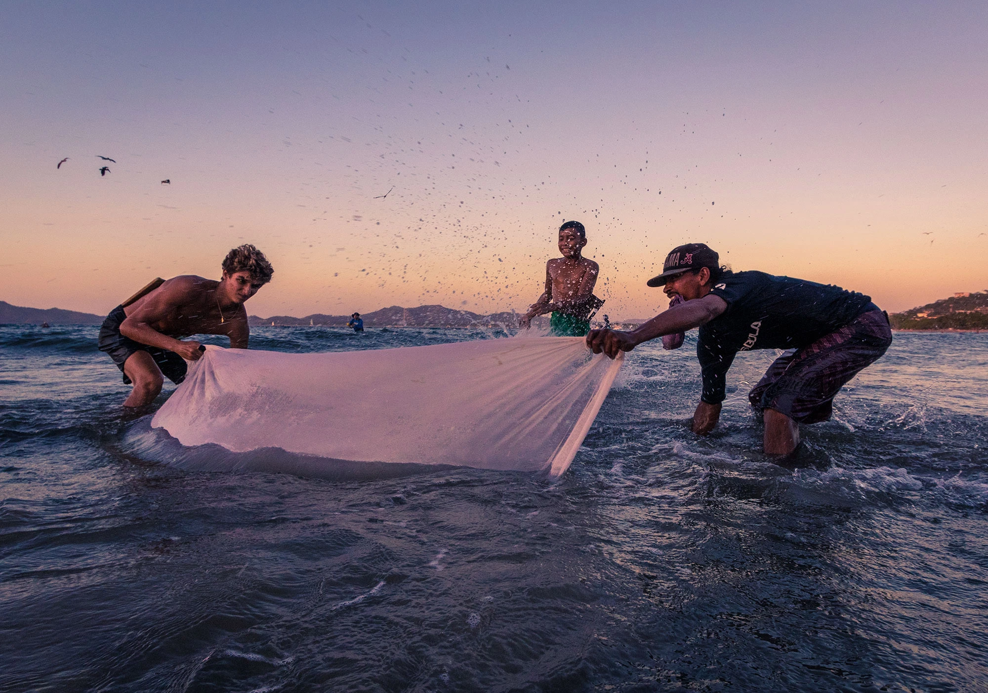 Fisherman casting a net along the beach in Tamarindo, Costa Rica